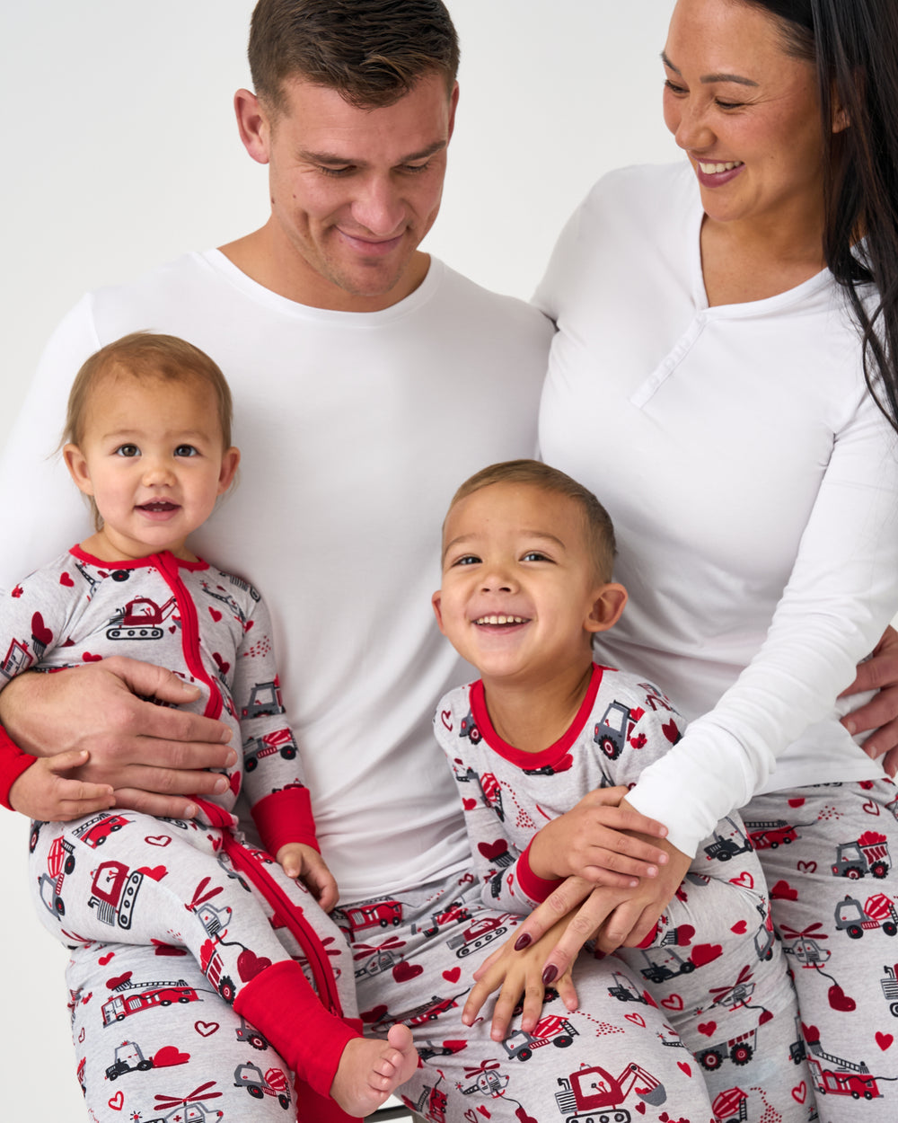 Close up of family of four wearing matching Loads of Love Valentines Day PJs