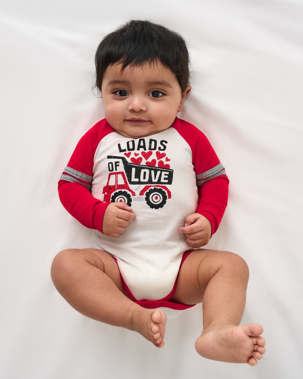 Aerial view of baby wearing the Loads of Love Raglan Bodysuit