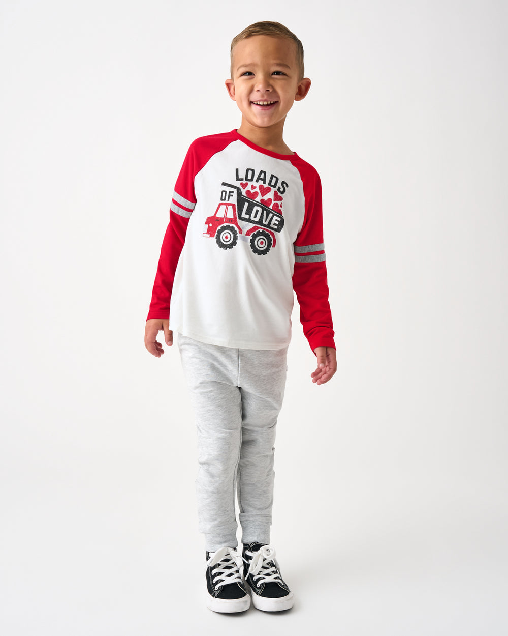 Boy wearing the Loads of Love Raglan Tee with grey joggers