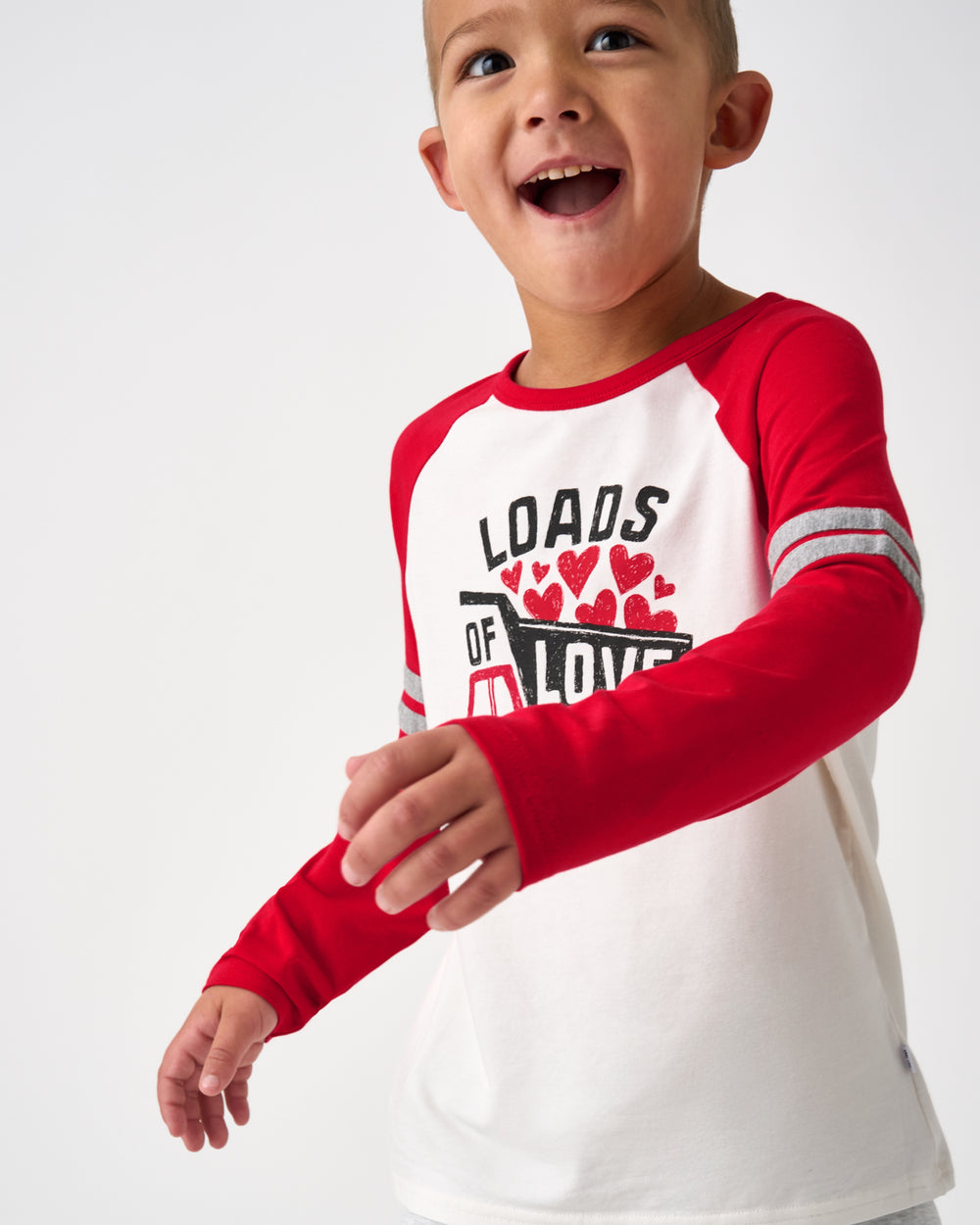 Boy in motion wearing the Loads of Love Raglan Tee