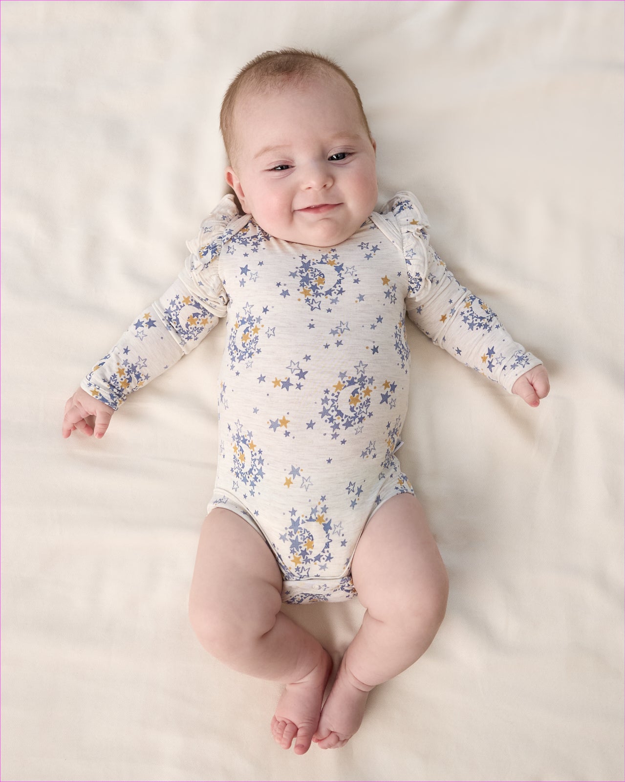 Aerial view of baby wearing the Lullaby Sky Flutter Bodysuit