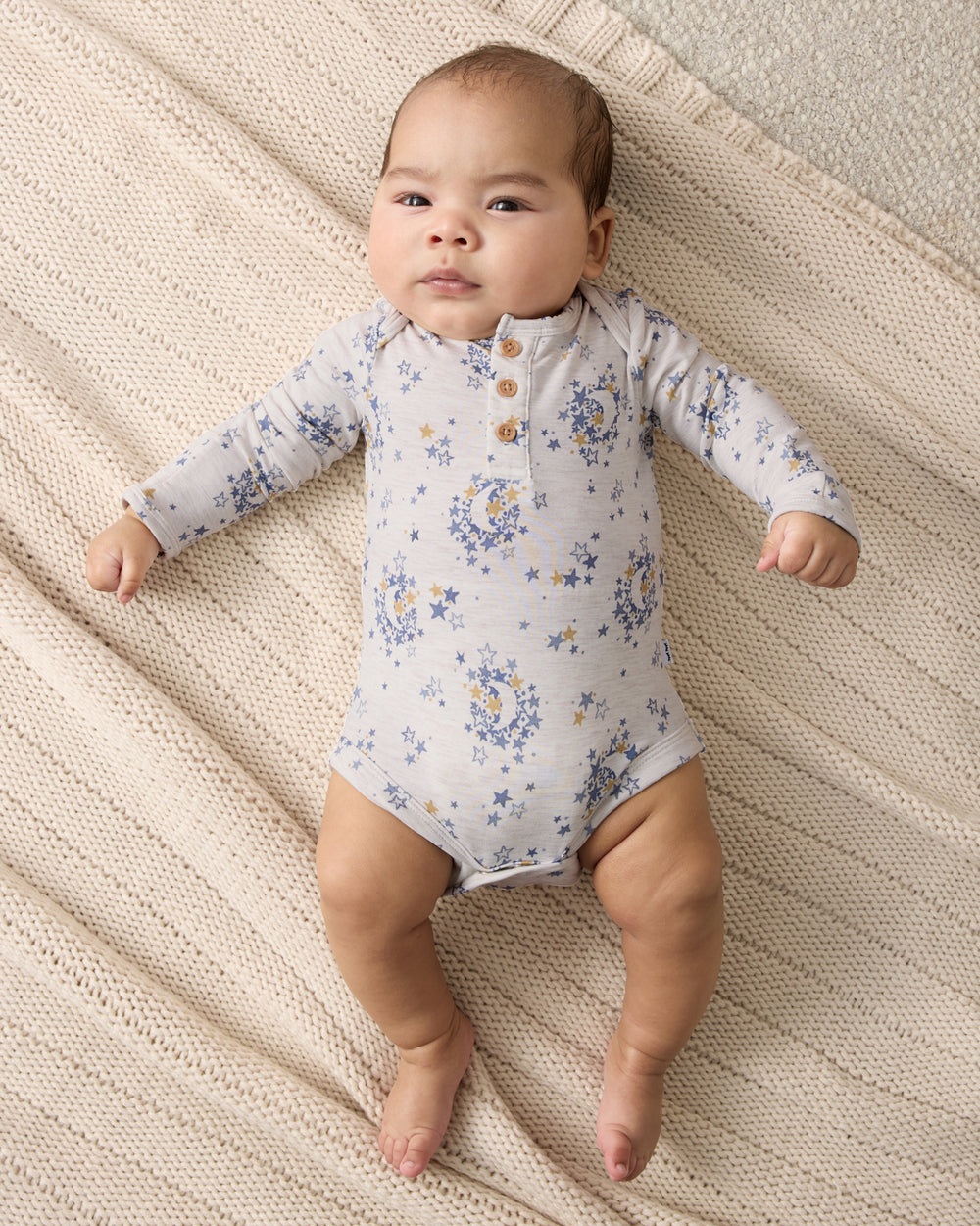 Aerial view of baby wearing the Lullaby Sky Henley Bodysuit