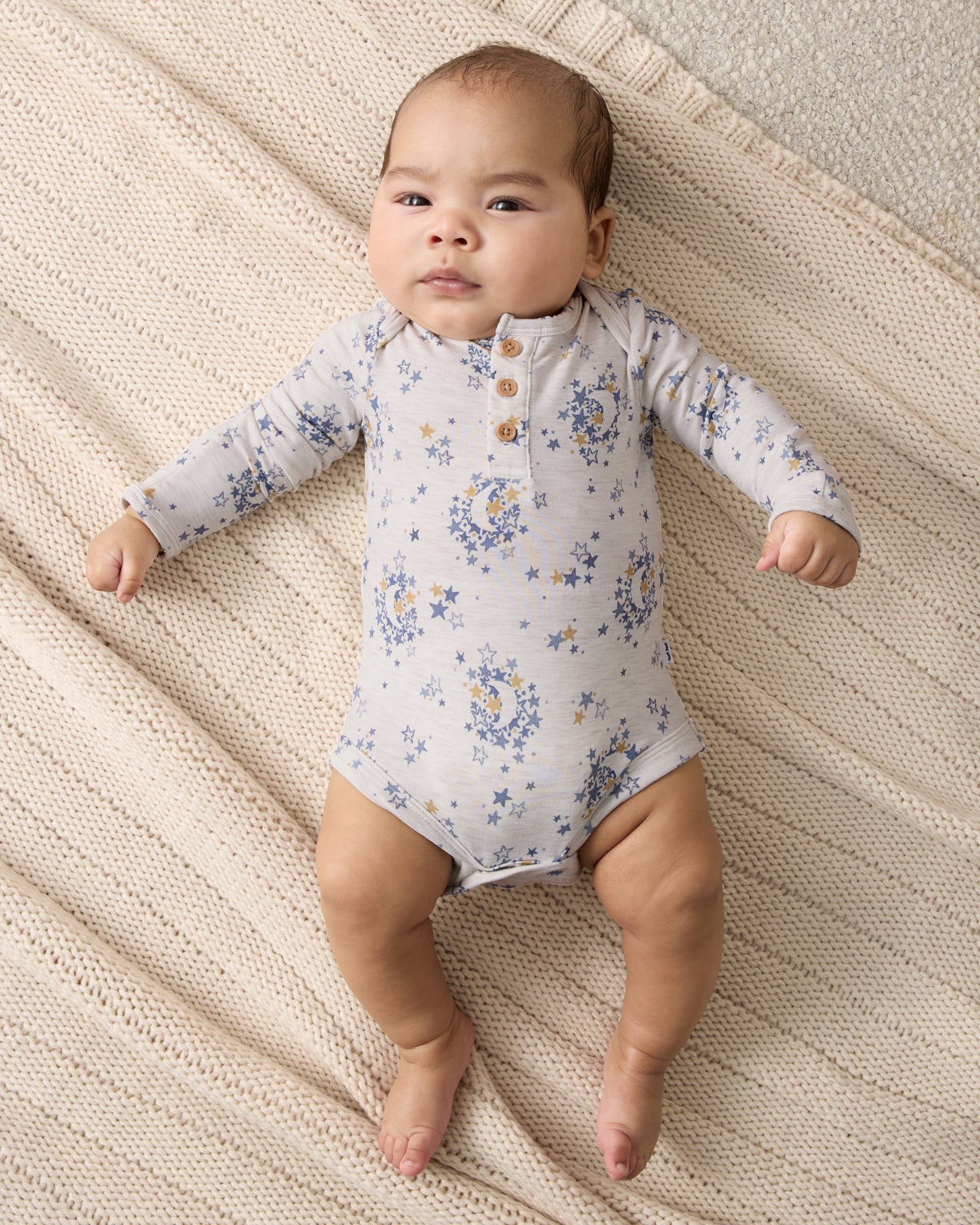 Aerial view of baby wearing the Lullaby Sky Henley Bodysuit