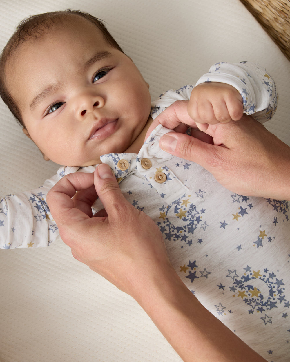 Adult demonstrating the henley button detail on the Lullaby Sky Henley Bodysuit