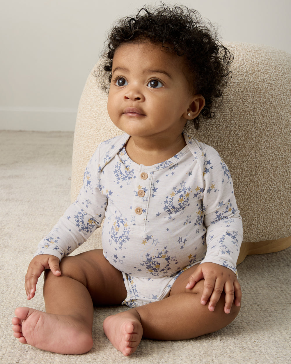 Sitting baby wearing the Lullaby Sky Henley Bodysuit