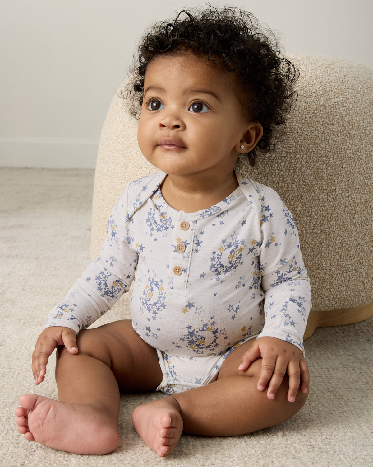 Sitting baby wearing the Lullaby Sky Henley Bodysuit
