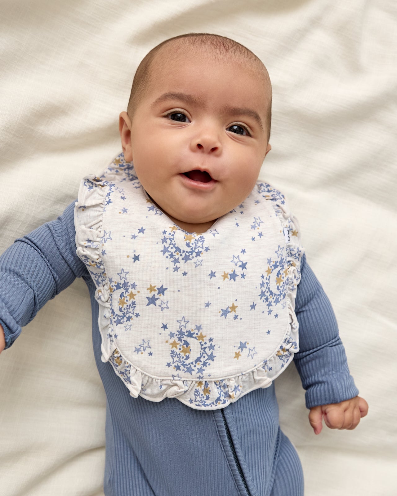 Baby wearing the Lullaby Sky Ruffle Bib