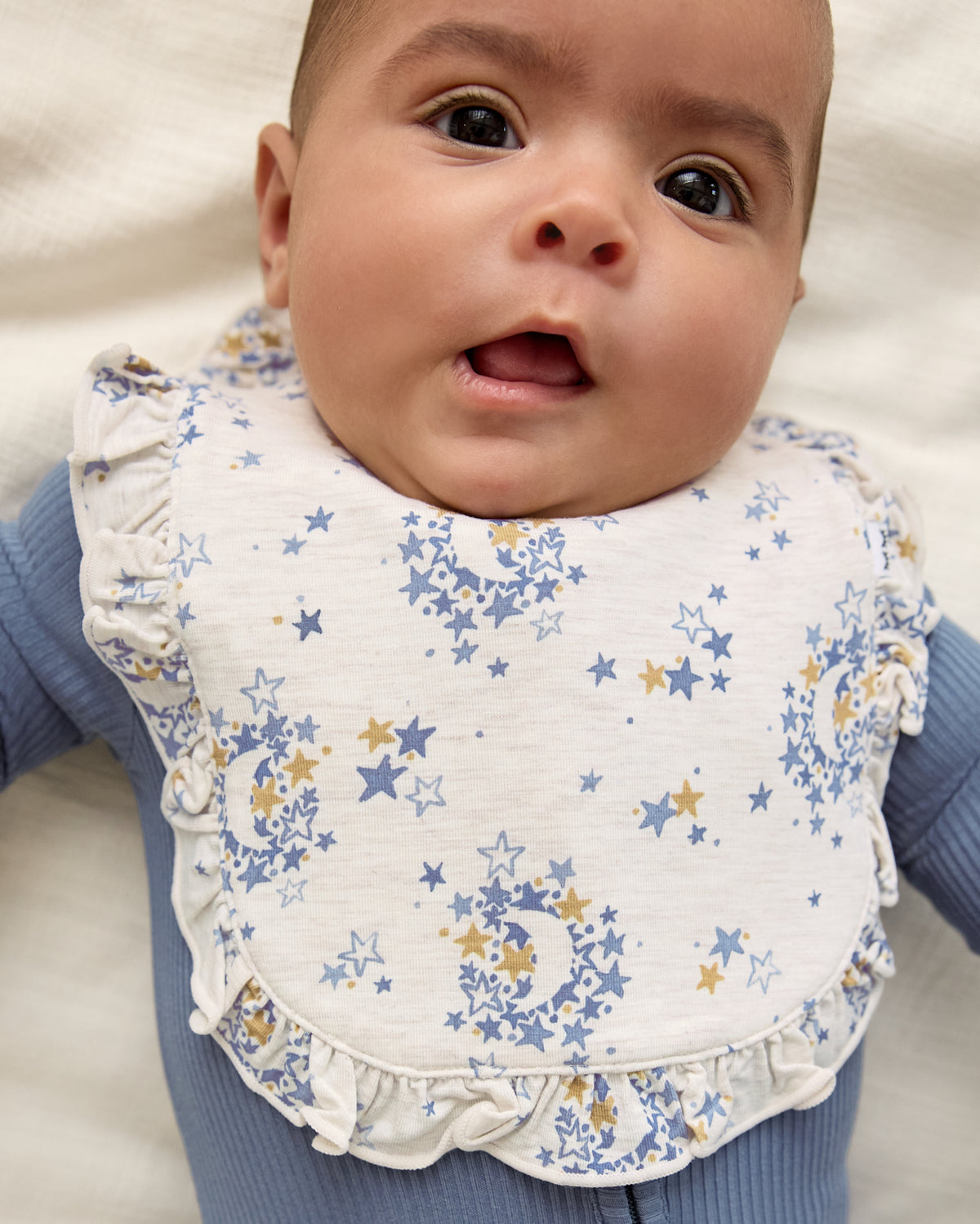 Close up of baby wearing the Lullaby Sky Ruffle Bib