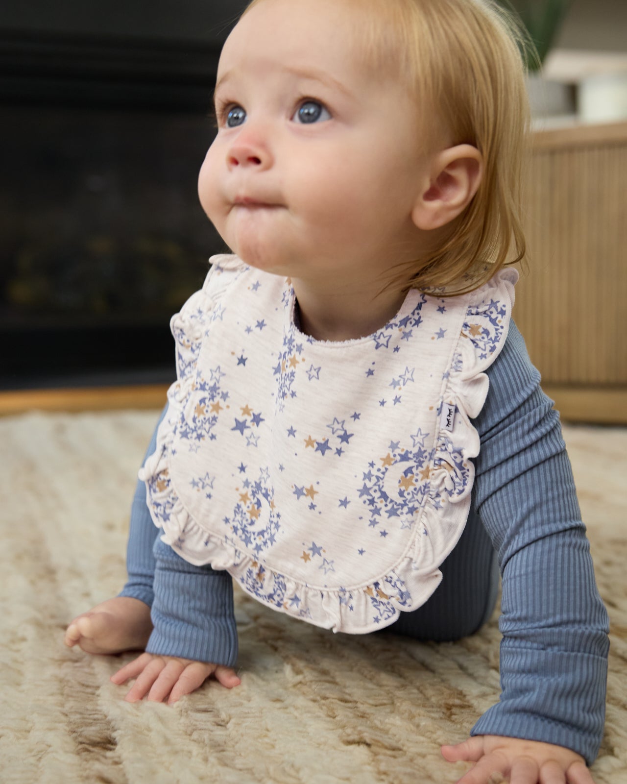 Crawling baby wearing the Lullaby Sky Ruffle Bib