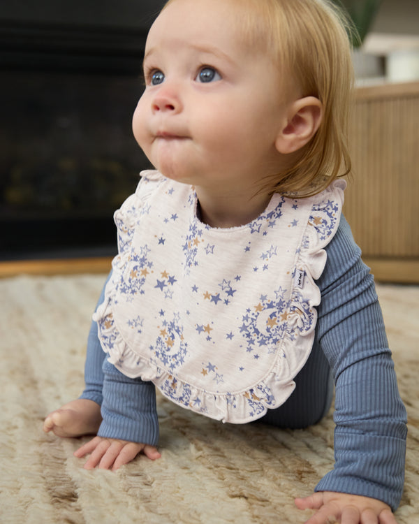 Crawling baby wearing the Lullaby Sky Ruffle Bib