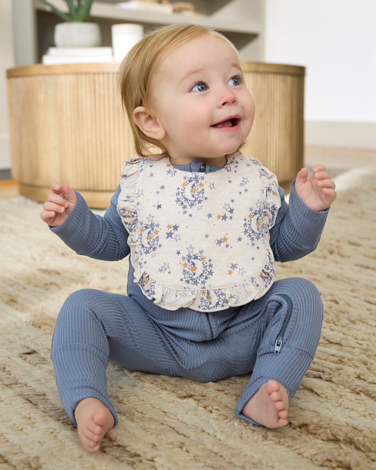 Sitting newborn wearing the Lullaby Sky Ruffle Bib
