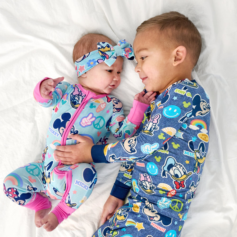 Two children laying wearing matching  Disney Mickey's Clubhouse pajamas