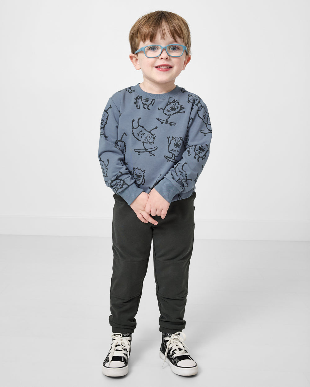 Boy wearing the Monster Moves Crewneck Sweatshirt with sweatpants