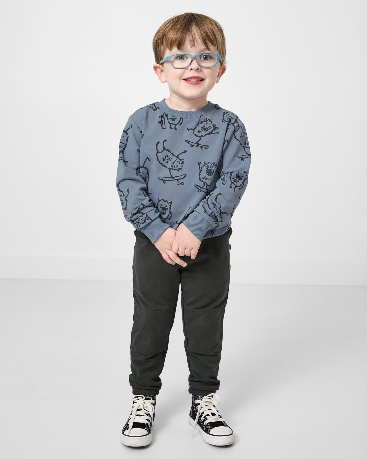 Boy wearing the Monster Moves Crewneck Sweatshirt with sweatpants