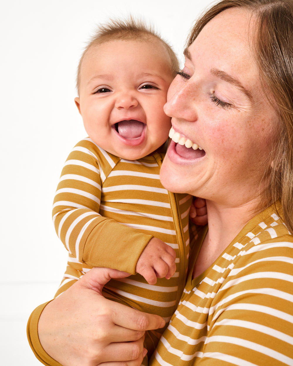 Mother holding baby wearing the Marigold Stripe Zippy
