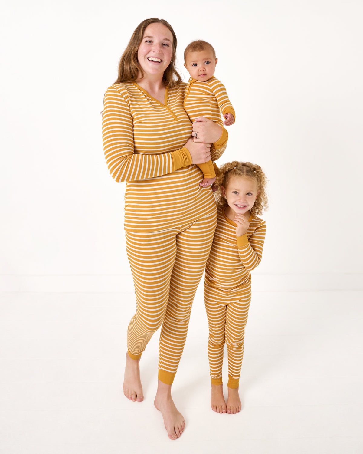 Mother and two children wearing matching Marigold Stripe pajamas