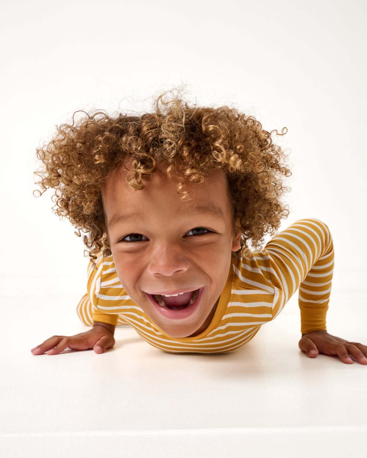 Close up of kid wearing the Marigold Stripe Two-Piece Pajama Set