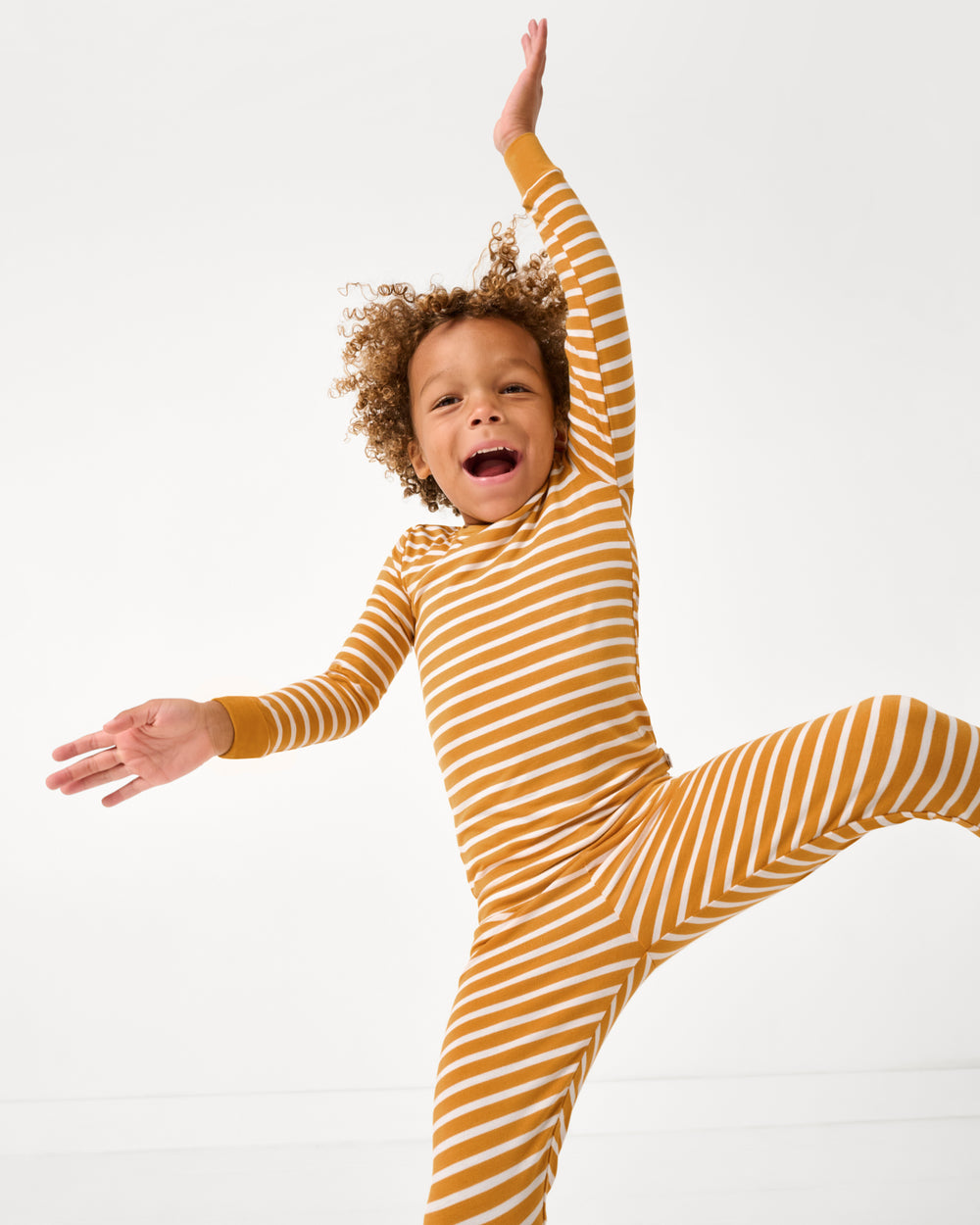 Child in motion wearing the Marigold Stripe Two-Piece Pajama Set