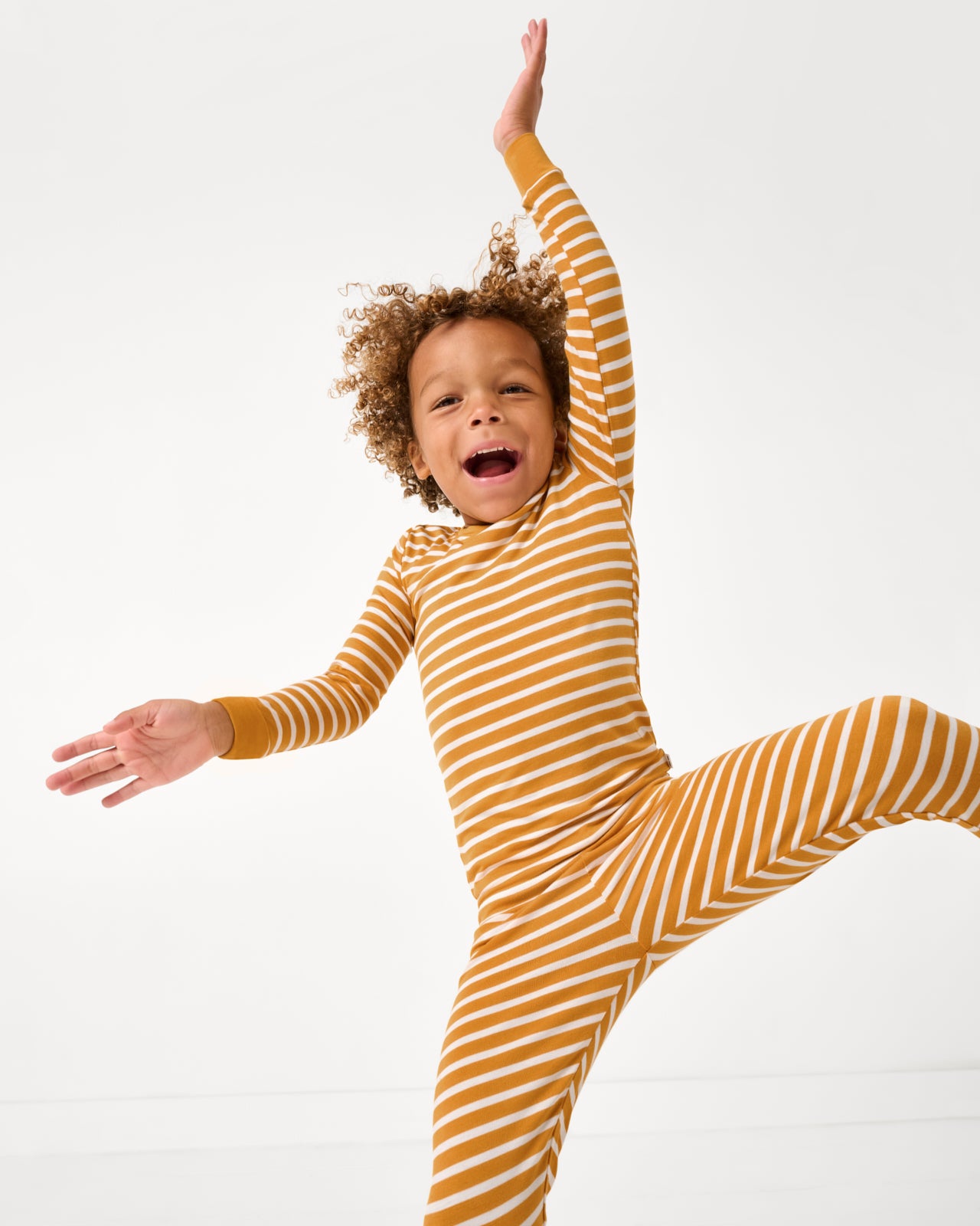 Child in motion wearing the Marigold Stripe Two-Piece Pajama Set
