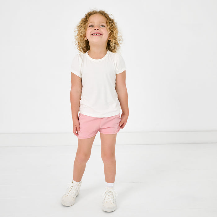 Girl wearing the Mauve Blush Dolphin Shorts with a white tshirt