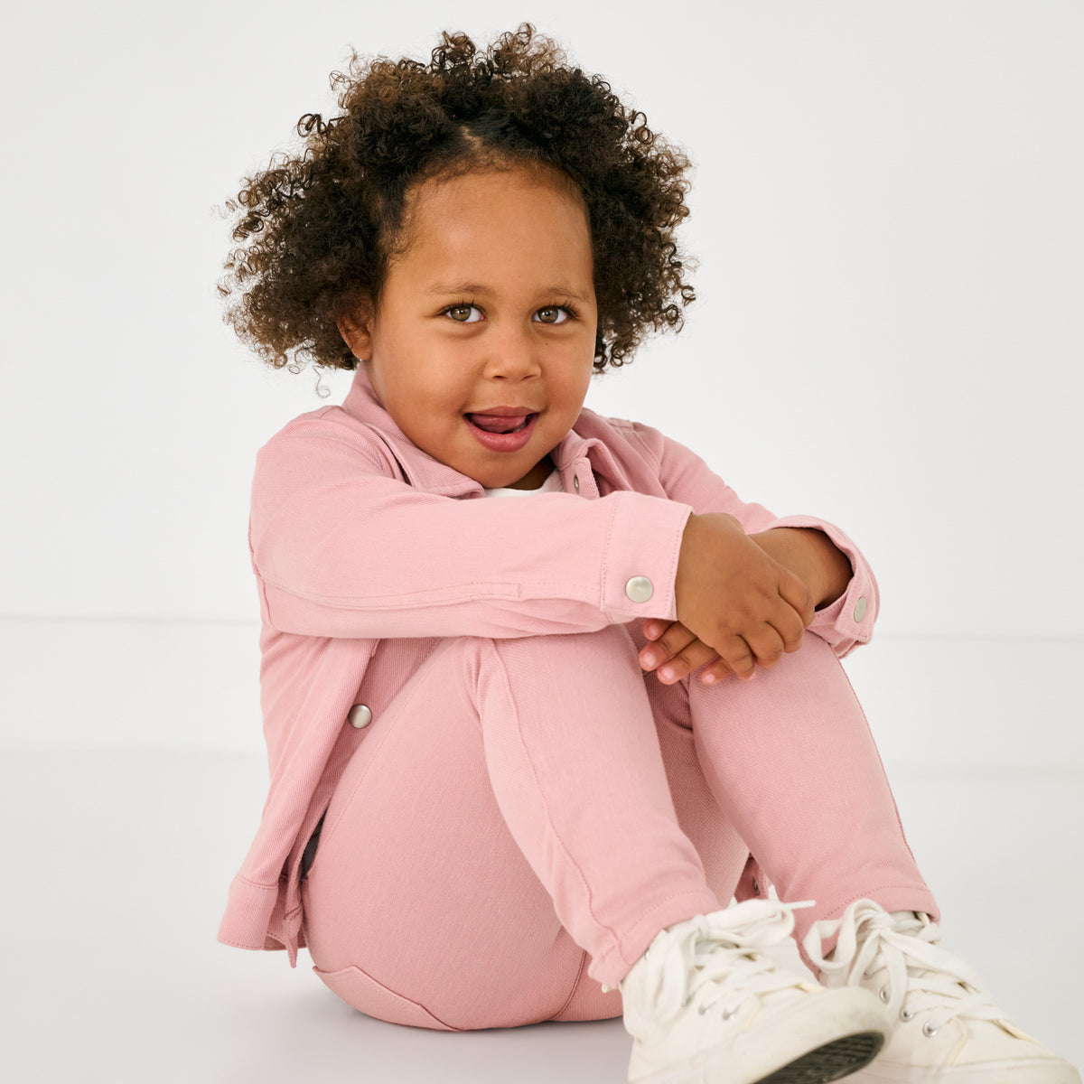 Sitting child wearing the Mauve Blush Denim Jegging