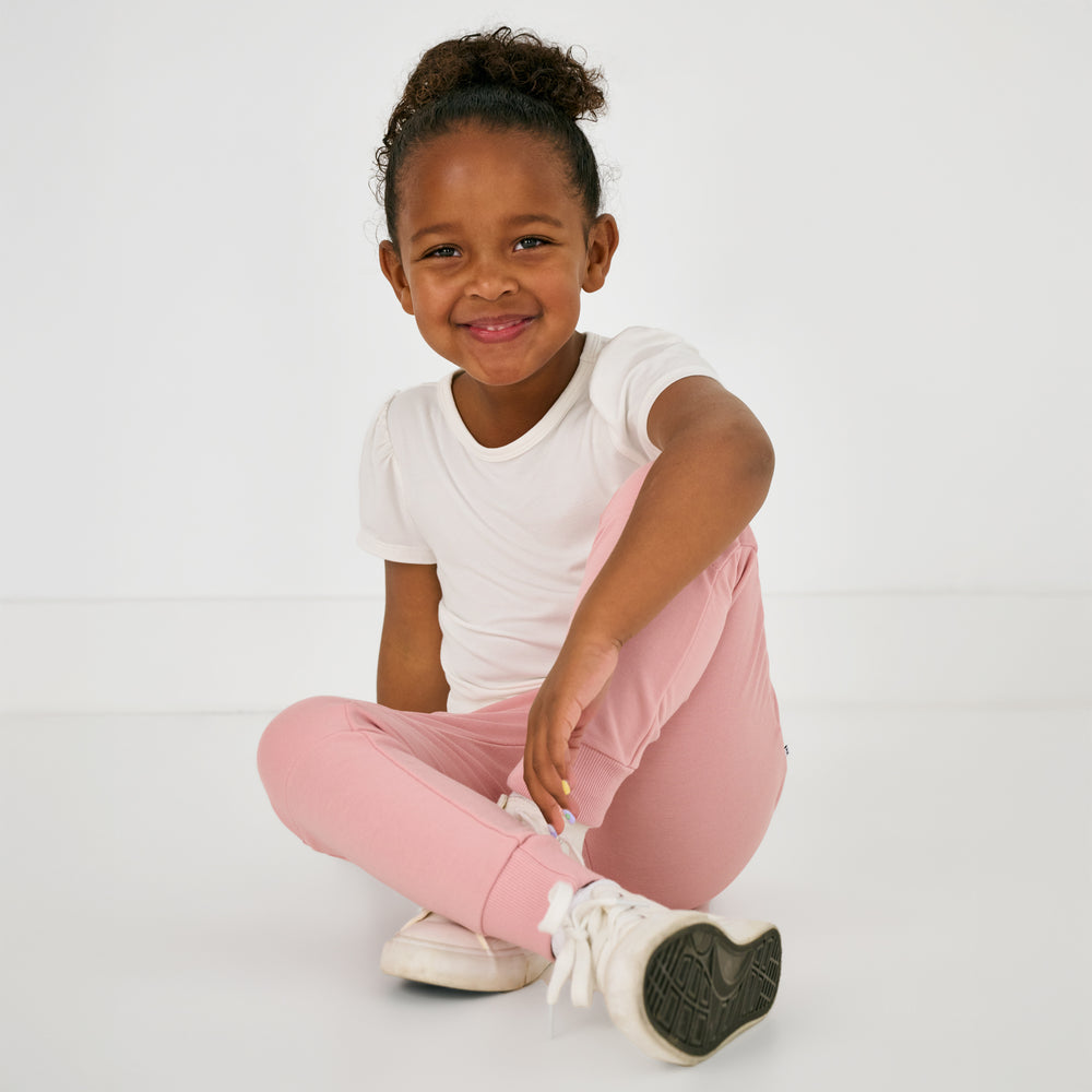Sitting child wearing the Mauve Blush Jogger