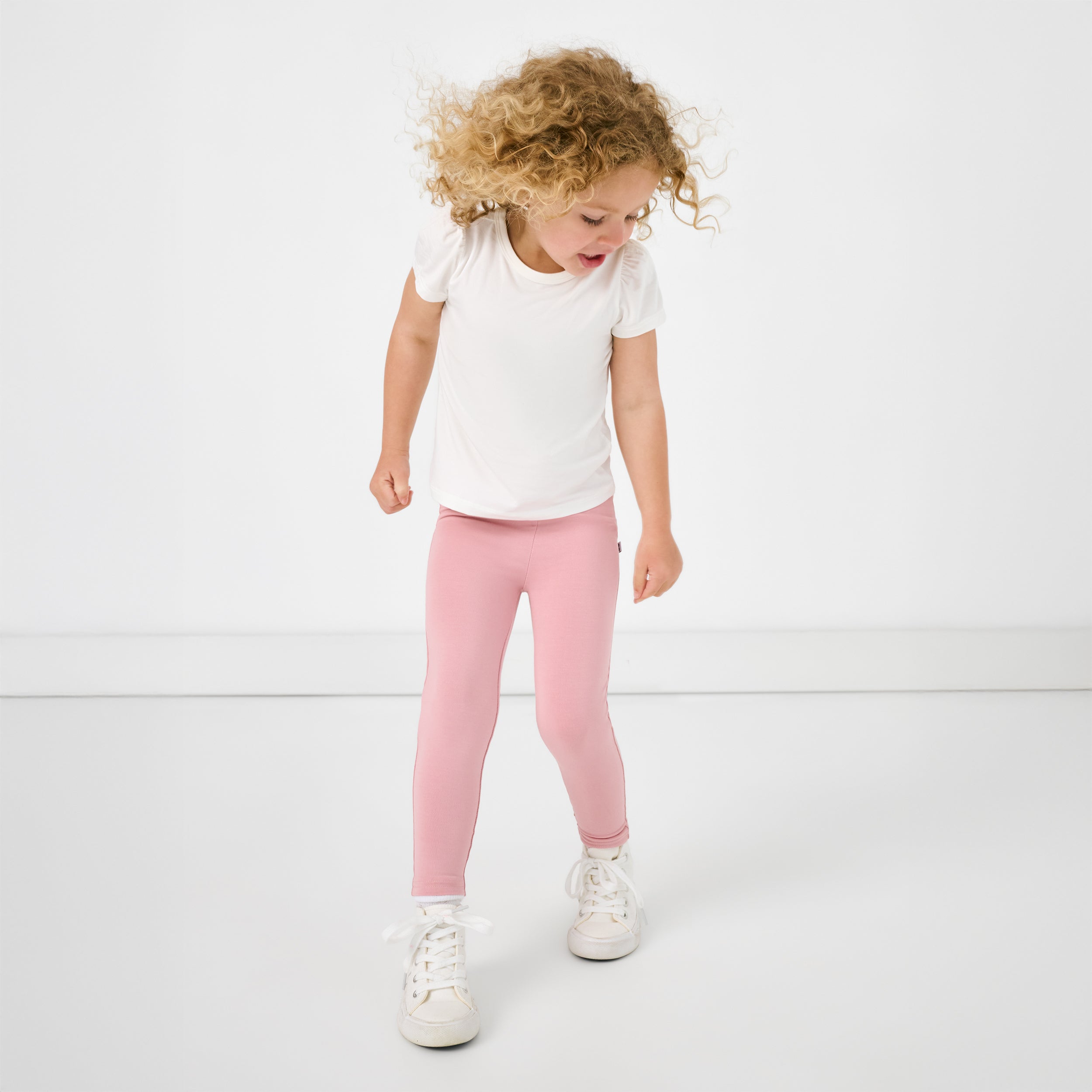 Child in motion wearing the Mauve Blush Legging and white puff sleeve tee
