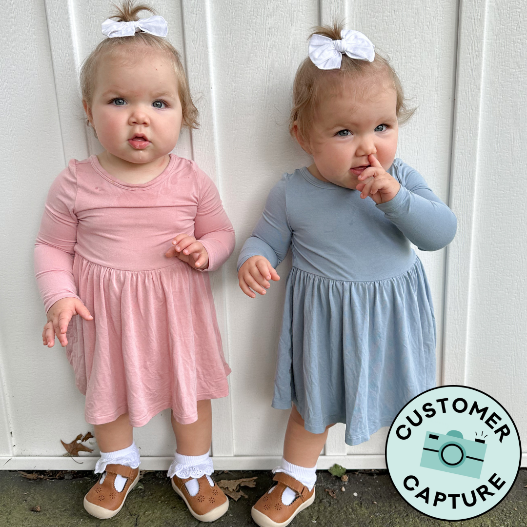 Customer Capture image of two children coordinating in Mauve Blush and Fog twirl dress with bodysuits