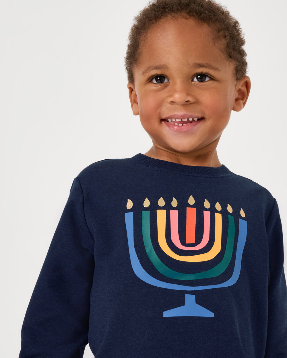 Close up of boy wearing the Menorah Crewneck Sweatshirt