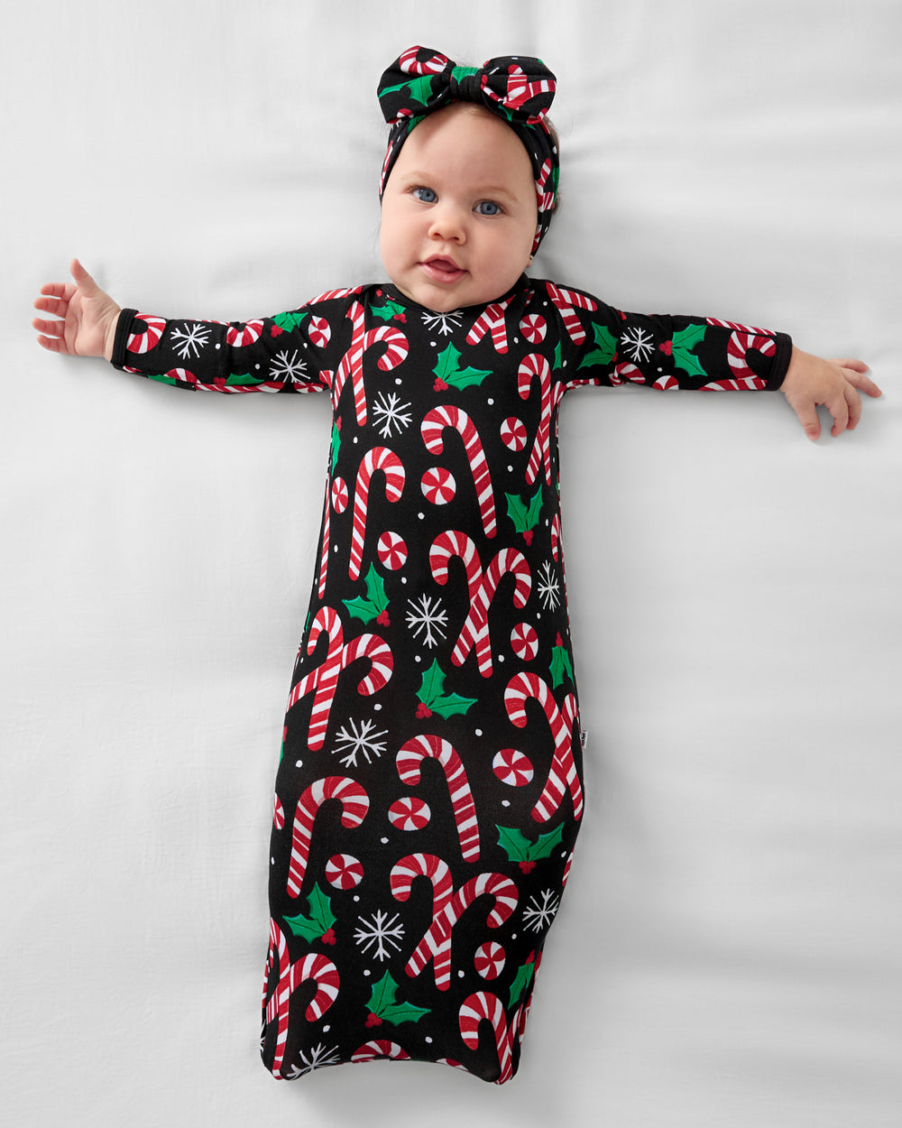 Aerial view of a baby wearing the Merry Mints Infant Gown with a matching bow headband