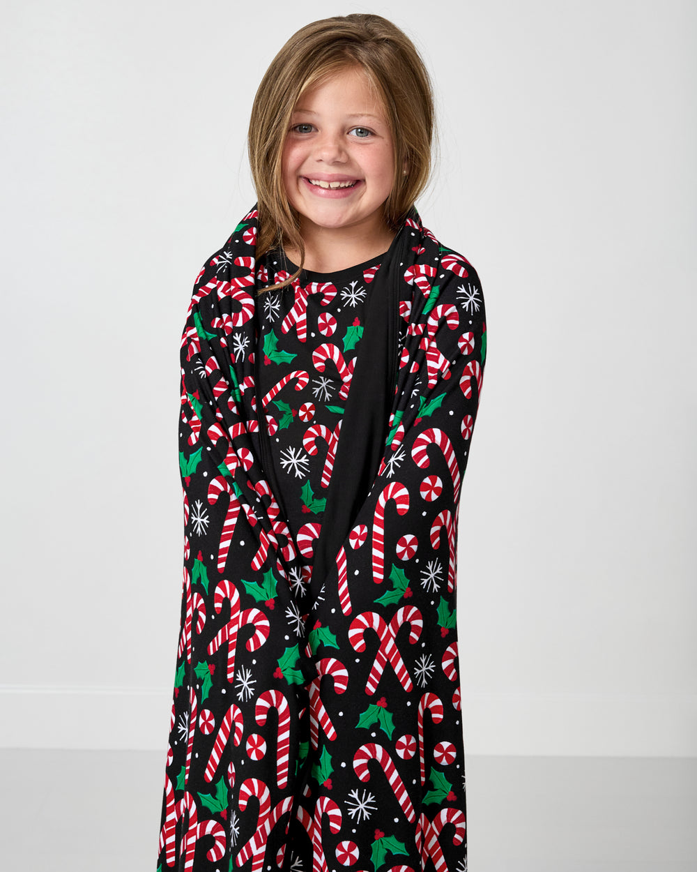 Girl wrapped in the Merry Mints Large Cloud Blanket®