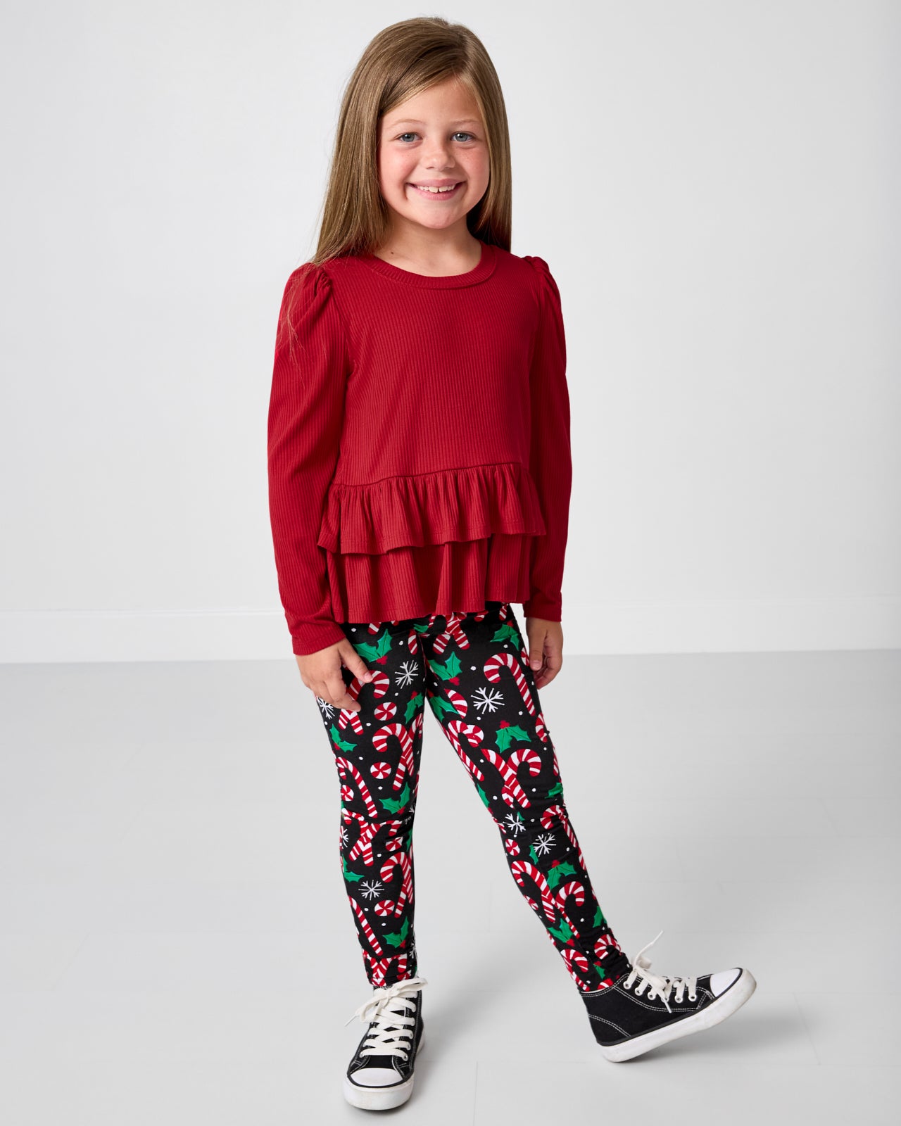 Girl wearing the Merry Mints Leggingwith a red peplum top