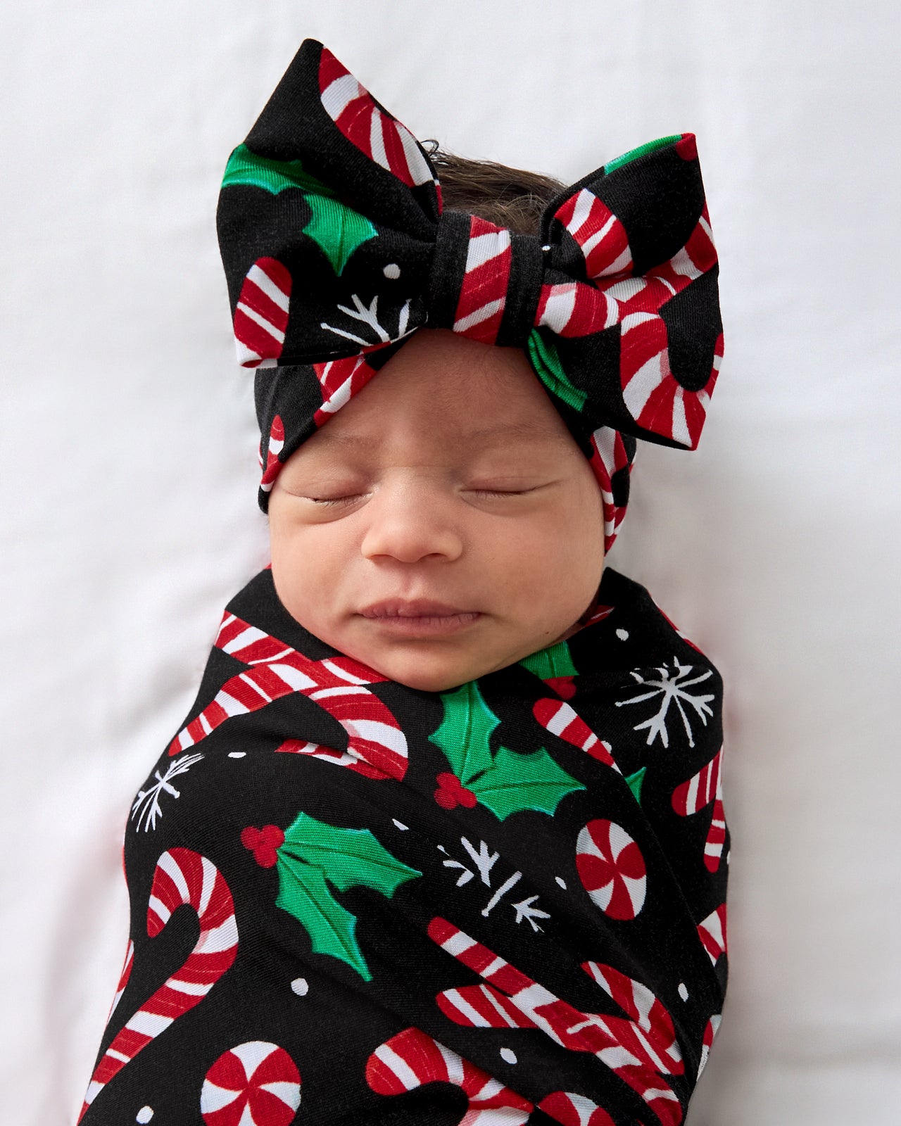 Close up of baby wearing the Merry Mints Swaddle & Luxe Bow Headband Set