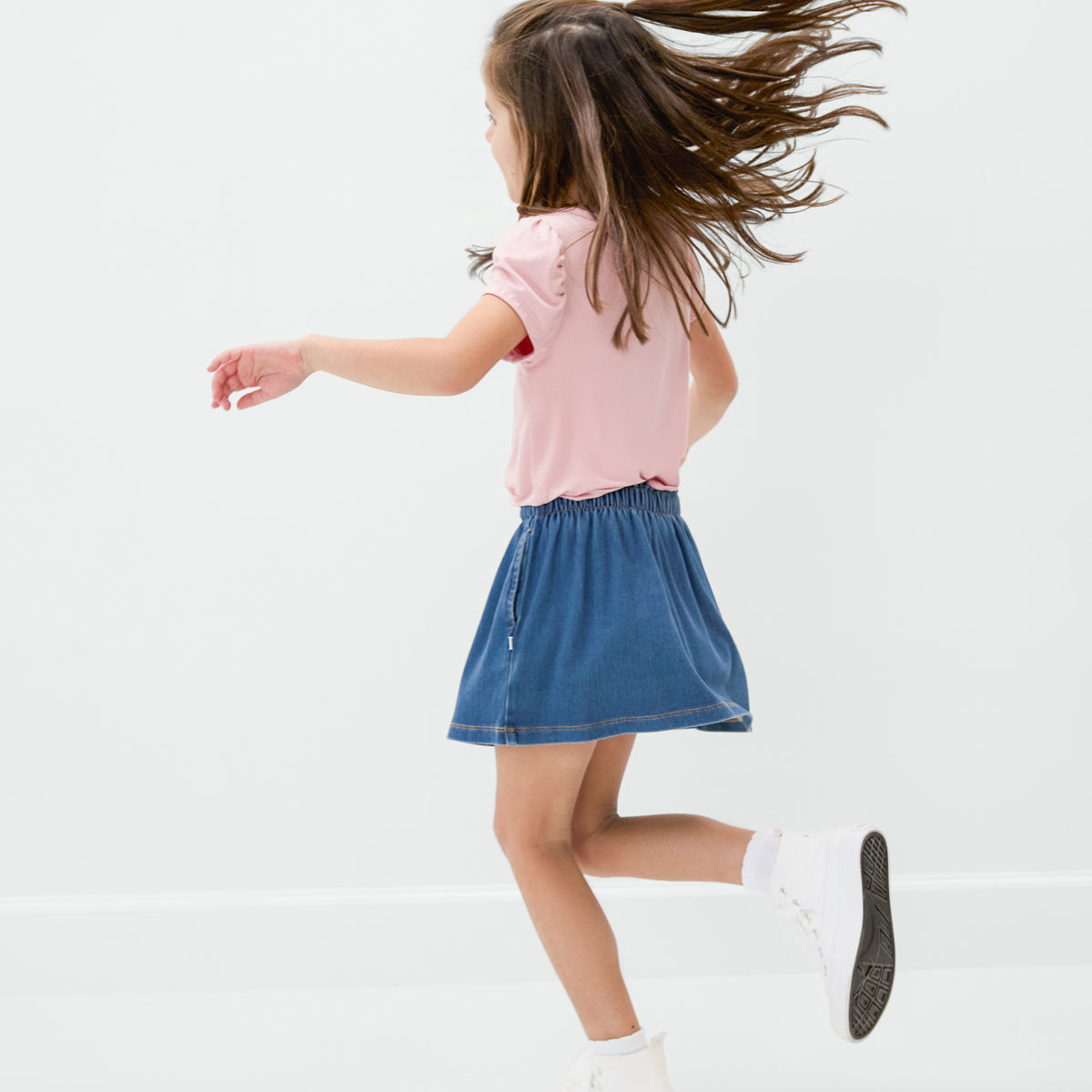 Dancing child wearing the Midwash Blue Denim Skort