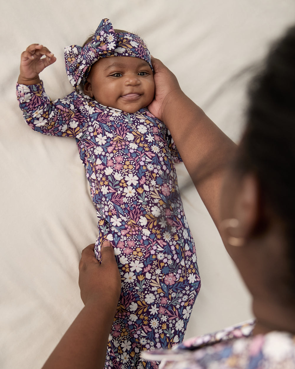 Mother holding newborn wearing the Midnight Petals Infant Gown