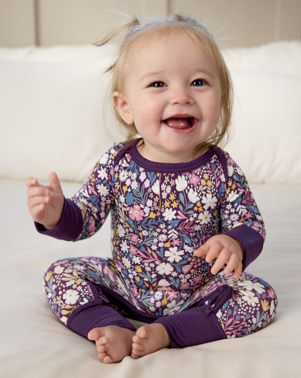 Sitting newborn wearing the Midnight Petals Crescent Zippy