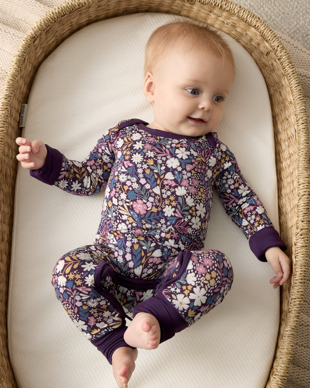 Newborn wearing the Midnight Petals Crescent Zippy in a woven basket