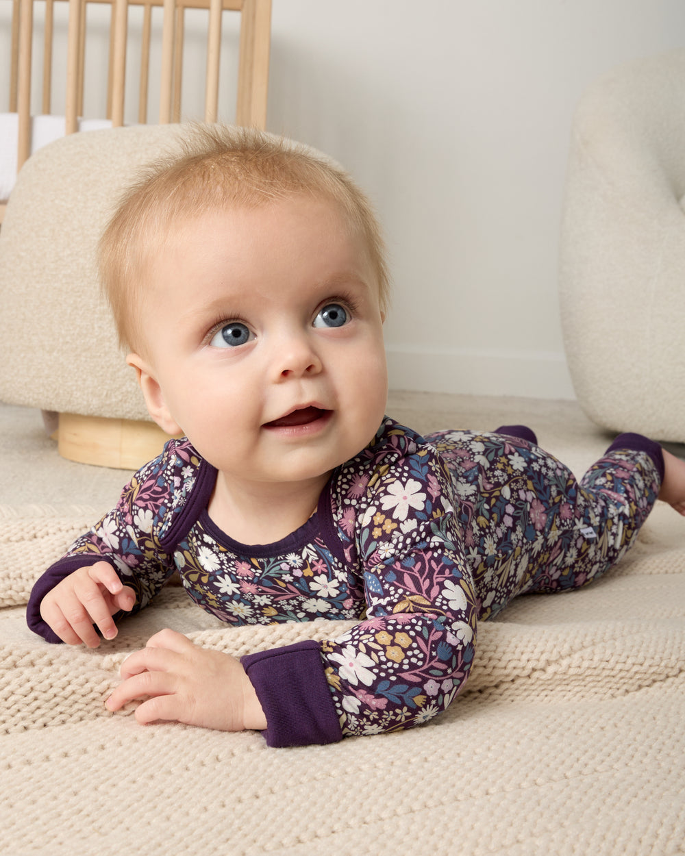 Newborn on her tummy wearing the Midnight Petals Crescent Zippy