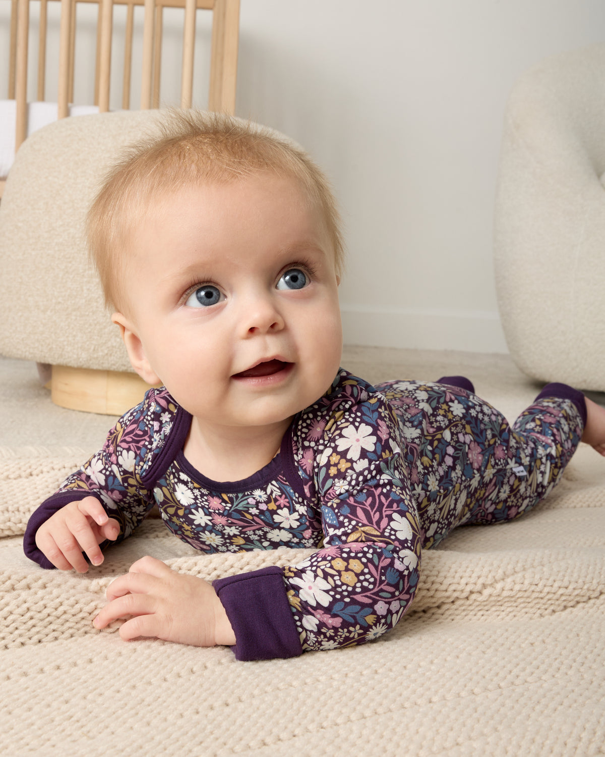 Newborn on her tummy wearing the Midnight Petals Crescent Zippy
