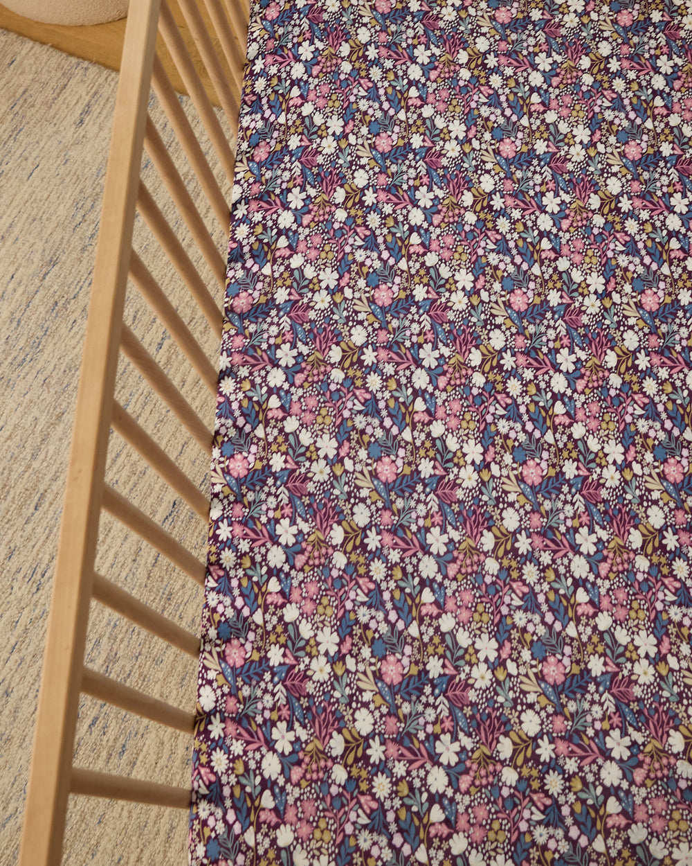Midnight Petals Fitted Crib Sheet in a wooden crib