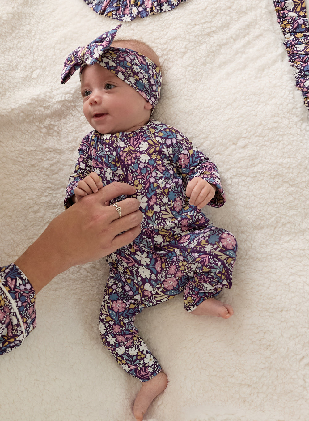 Aerial view of baby wearing the Midnight Petals Luxe Bow Headband and Zipper Pajamas