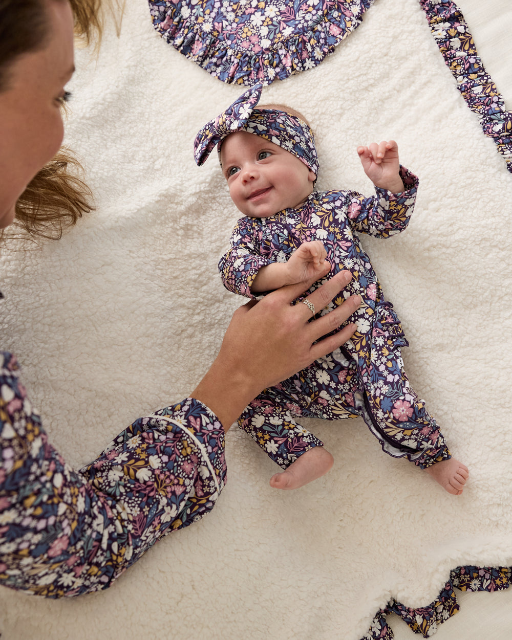 Newborn laying on the Midnight Petals Sherpa Ruffle Mini Cloud Blanket®
