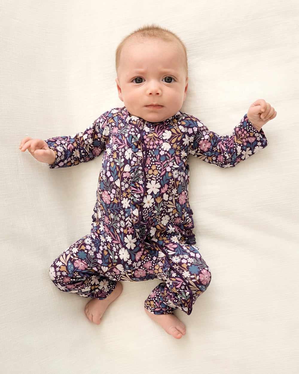 Newborn wearing the Midnight Petals Ruffle Zippy