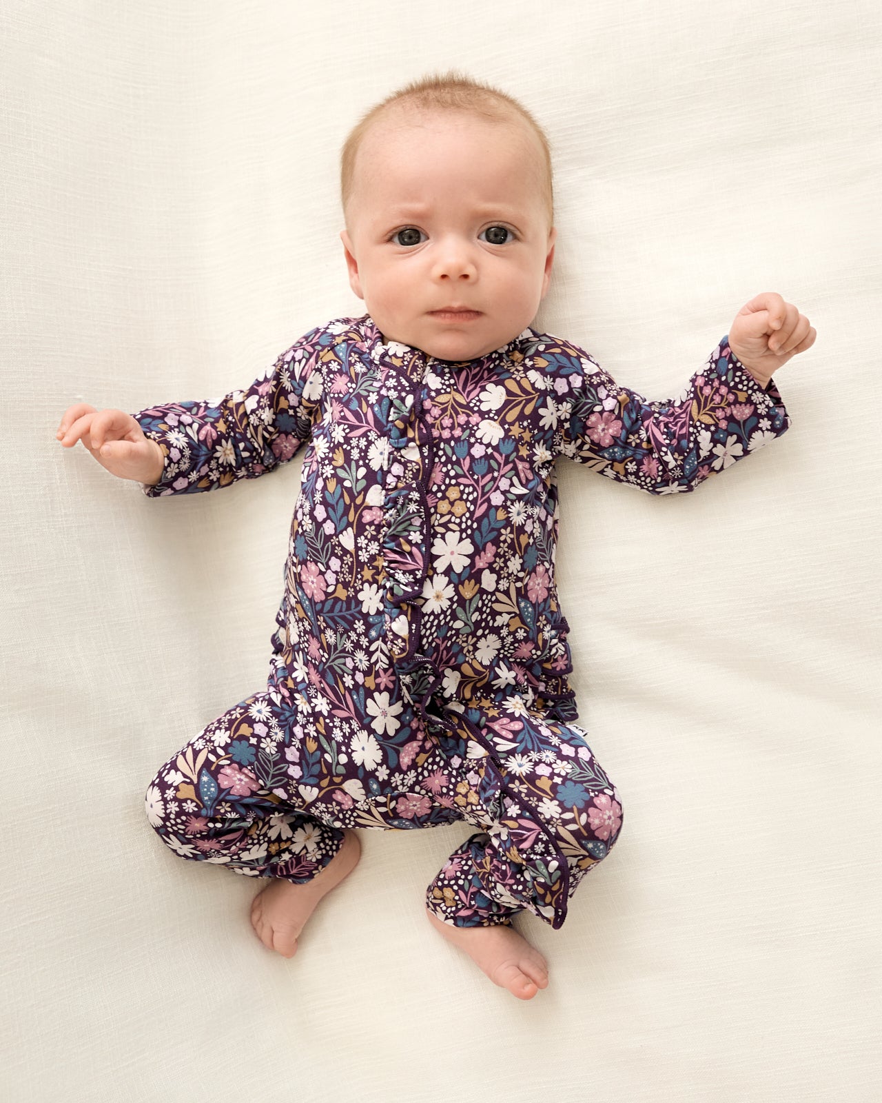 Newborn wearing the Midnight Petals Ruffle Zippy