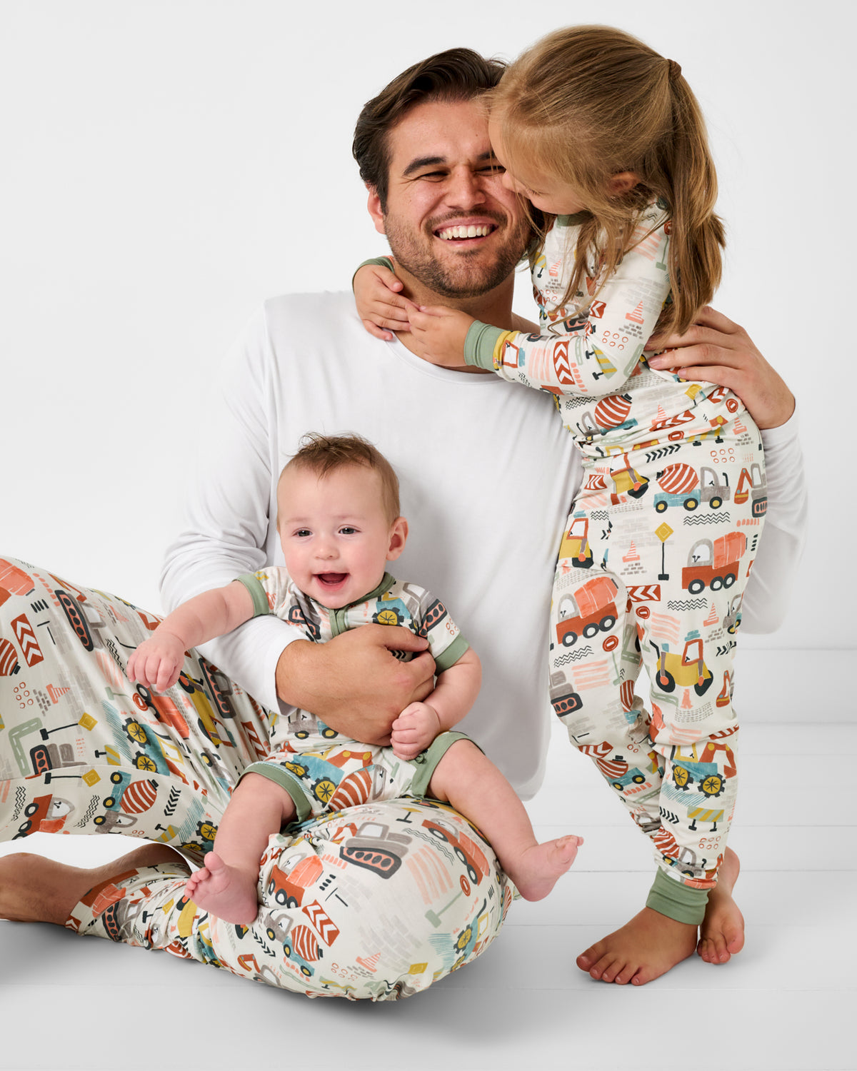 Father and two children wearing matching Mini Builders bamboo Pajamas