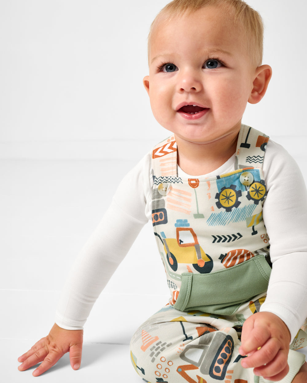 Close up of baby wearing the Mini Builders Construction themed Overall