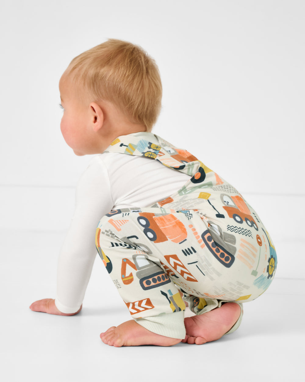Crawling baby wearing the Mini Builders Overall Romper