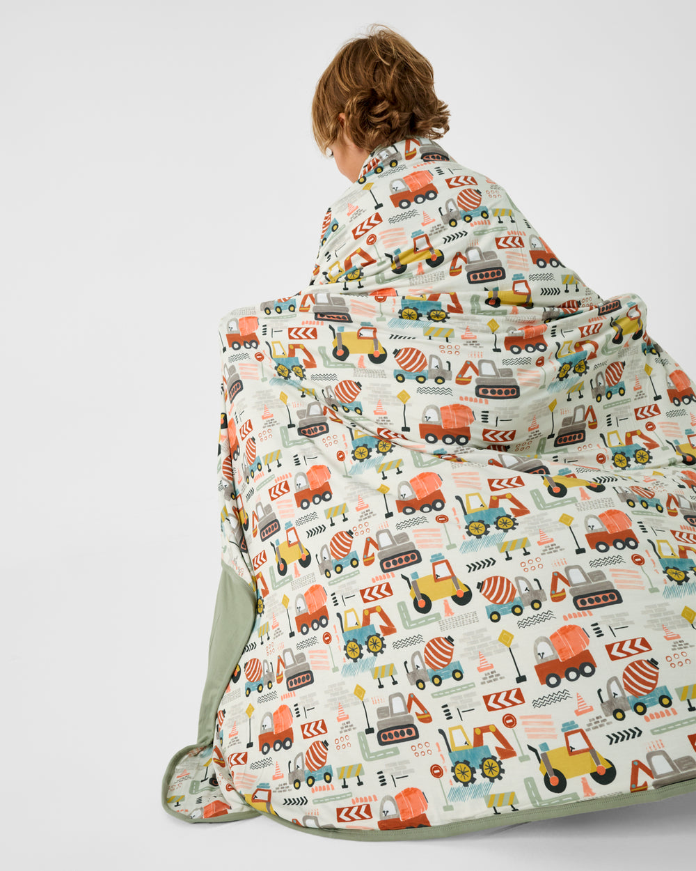 Back view of boy wrapped in the Mini Builders Large Cloud Blanket®