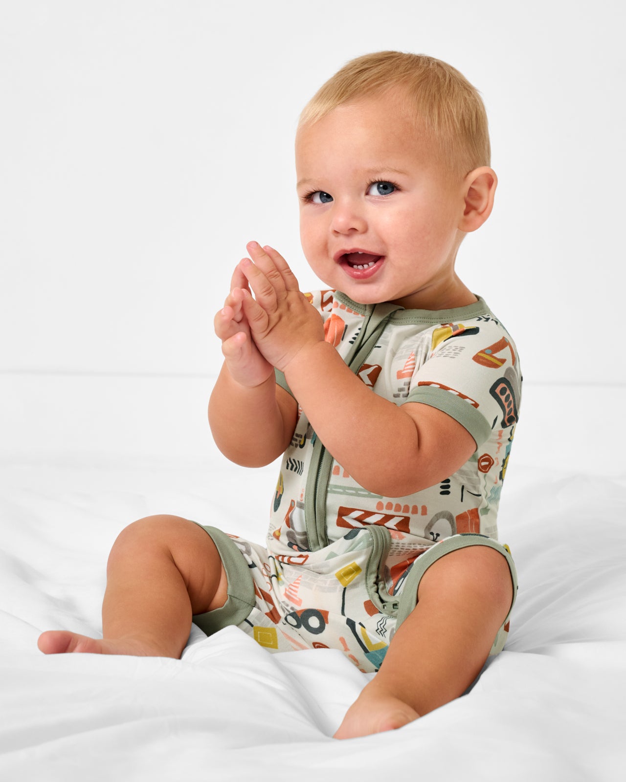 Sitting baby wearing the Mini Builders Shorty Zippy