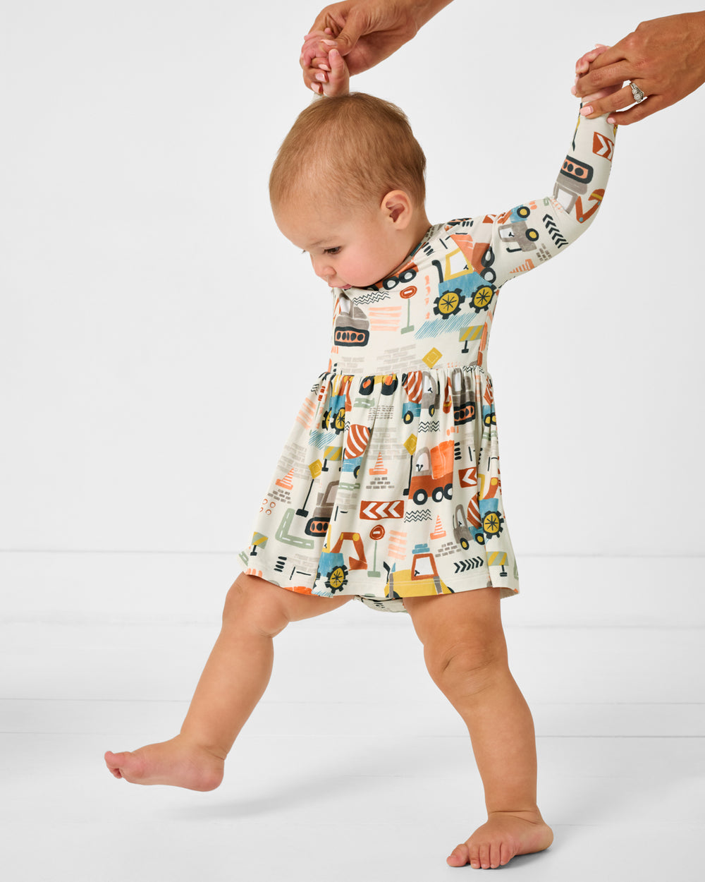 Walking toddler wearing the Mini Builders Skater Dress with Bodysuit